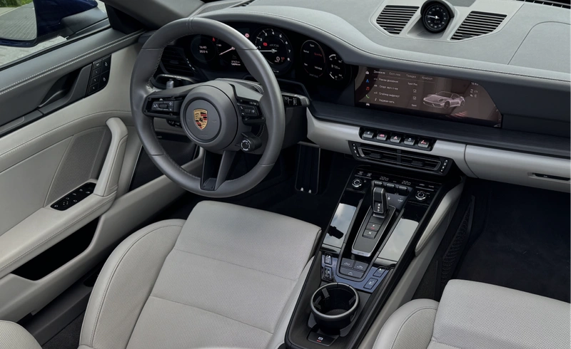 Wnętrze Porsche 911 Carrera 4 GTS Cabriolet – jasna skórzana tapicerka, kierownica i konsola środkowa, wynajem Warszawa SK CARS