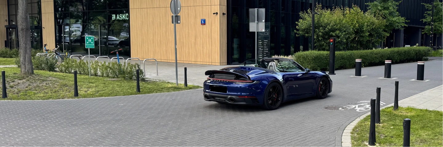 Porsche 911 Carrera 4 GTS Cabriolet в тёмно-синем цвете – вид сзади в движении, аренда Варшава SK CARS