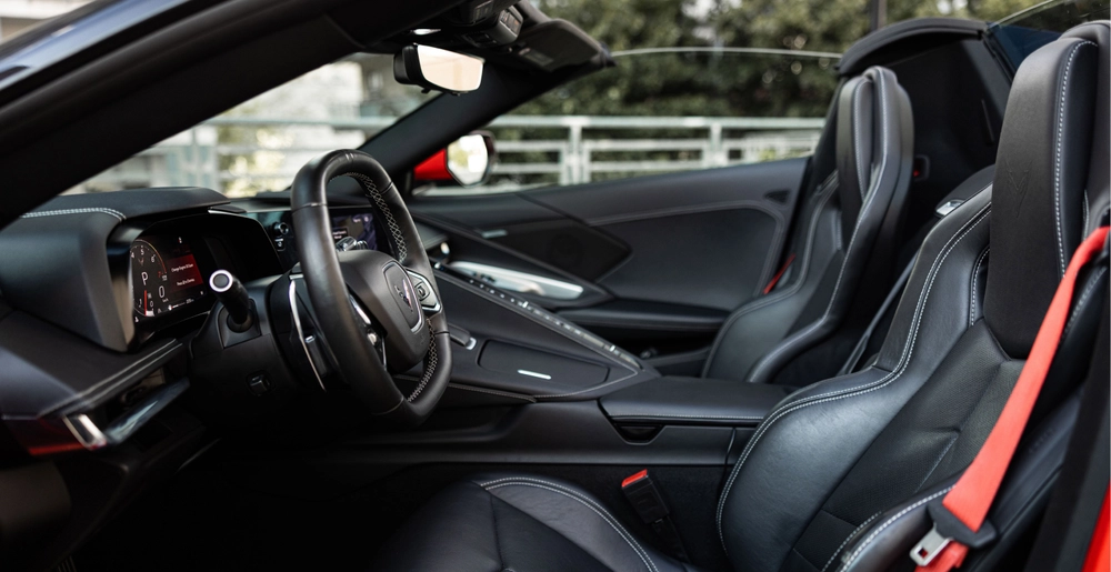 Sportowe fotele i czarne skórzane wnętrze Chevrolet Corvette C8 Stingray Cabrio z otwartym dachem.