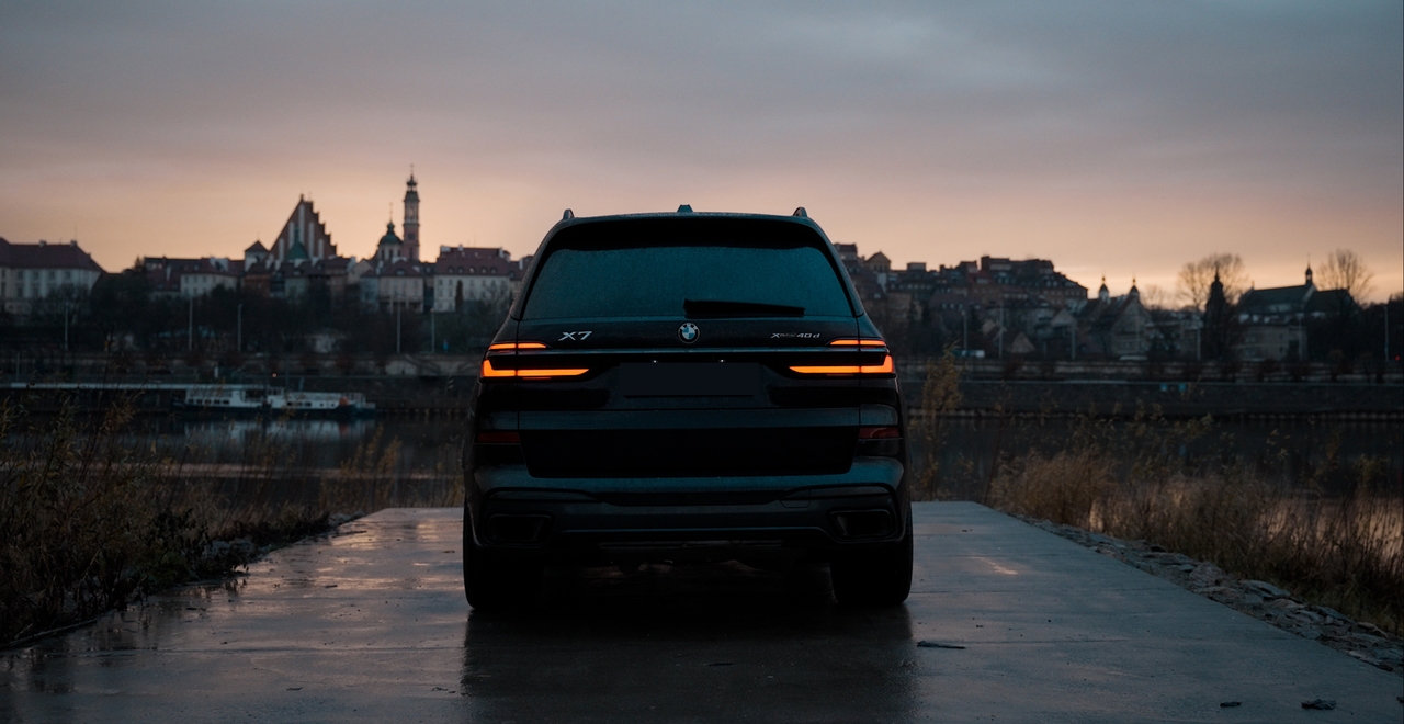 BMW X7 xDrive40d zaparkowany nad Wisłą w Warszawie o świcie – luksusowy SUV do wynajęcia w SK CARS.