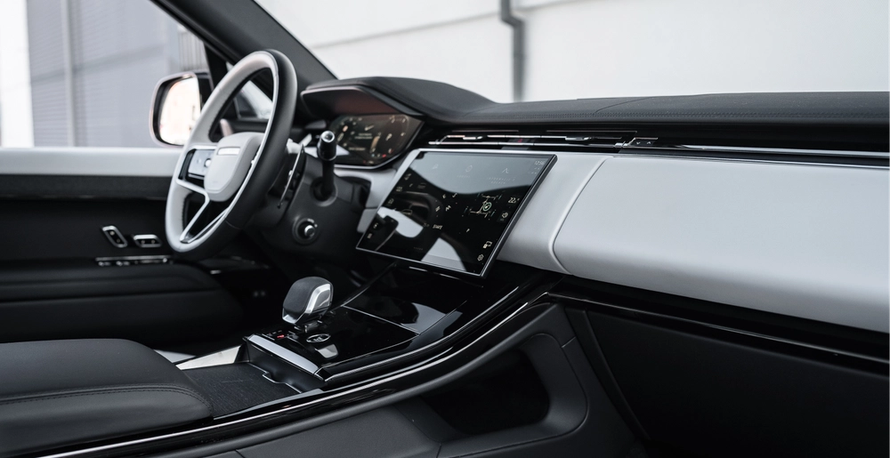 Передняя панель и цифровой мультимедийный экран Range Rover Sport с премиальной отделкой салона.