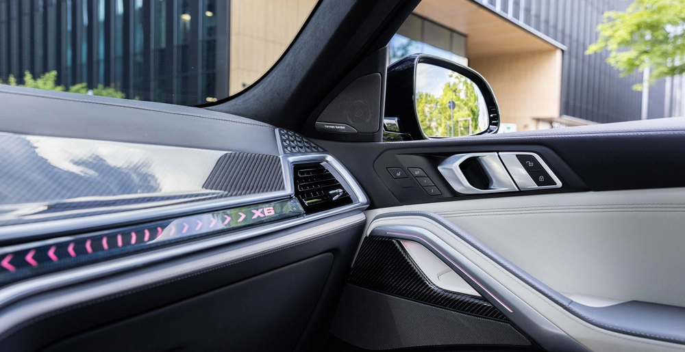 Wnętrze BMW X6 – podświetlenie ambientowe, wykończenia z karbonu, głośniki Harman Kardon. Widok z fotela pasażera.