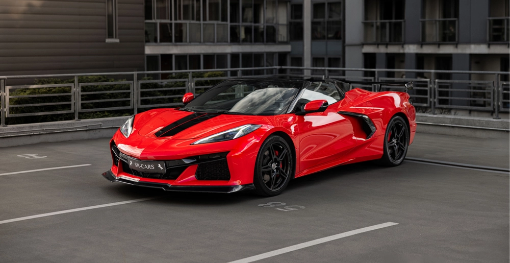 Czerwony Chevrolet Corvette C8 Stingray Cabrio z otwartym dachem, widok z przodu pod kątem, wynajem samochodu sportowego w Warszawie.