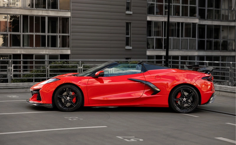 Czerwony Chevrolet Corvette C8 Stingray Cabrio z otwartym dachem, widok z boku, wynajem sportowego kabrioletu w Warszawie.