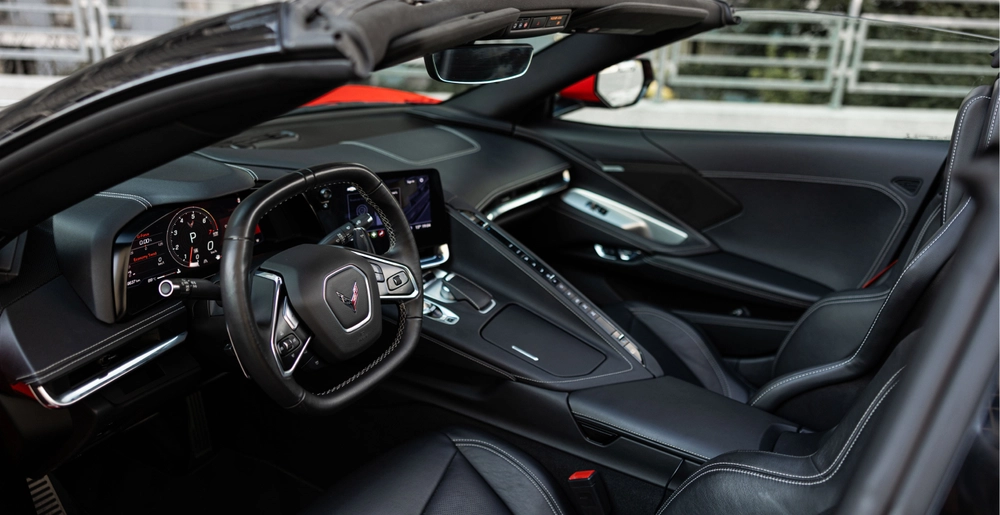Czarne skórzane wnętrze Chevrolet Corvette C8 Stingray Cabrio z kierownicą, cyfrowymi zegarami i konsolą środkową.