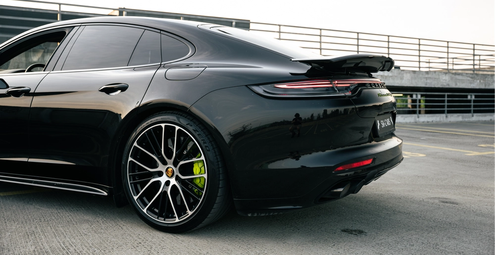 Задняя часть Porsche Panamera Turbo S E-Hybrid с активным спойлером и светодиодной полосой.