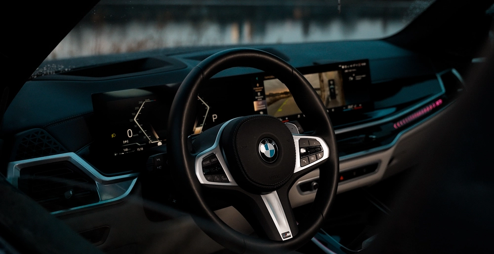 Sportowa kierownica BMW X7 xDrive 40 z logo M i cyfrowy kokpit z ekranem cofania. Luksus w każdym detalu. Dostępny w SK CARS Warszawa.