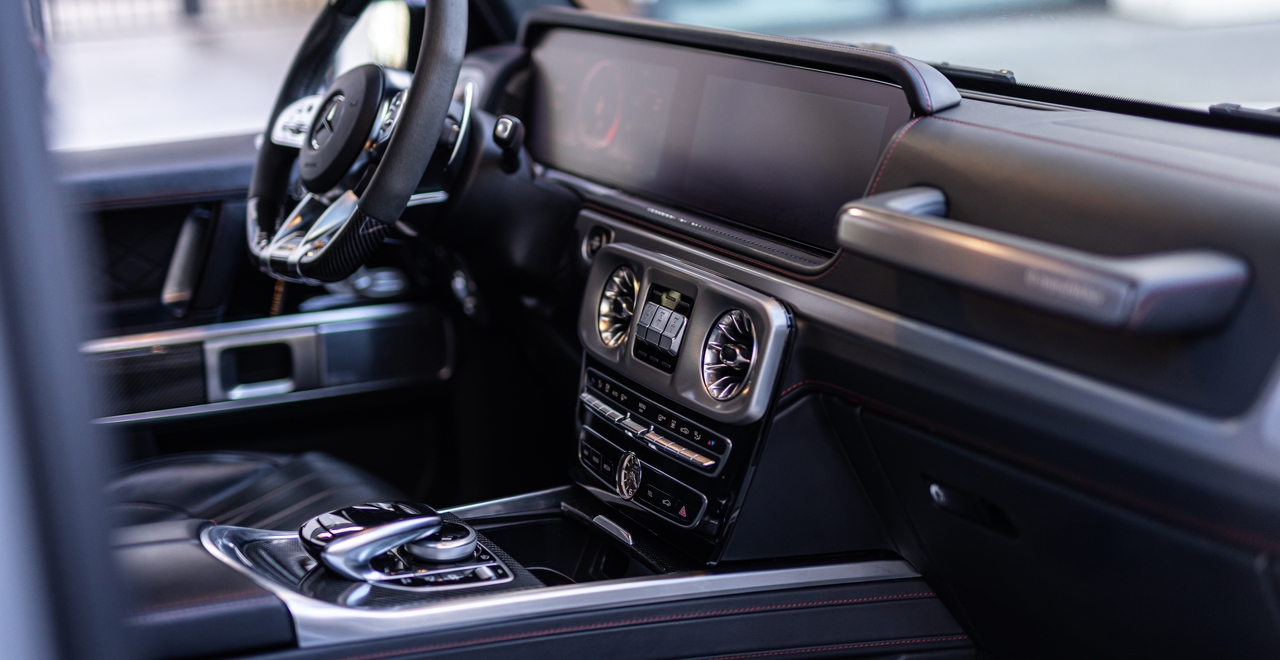 Mercedes-AMG G63 central console with dual displays, iconic turbine air vents, and differential lock switches — everything within reach, everything in control.