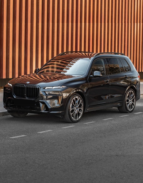 Luksusowy SUV BMW X7 xDrive 40 w czarnym kolorze zaparkowany na ulicy Warszawy – wynajem samochodów premium w SK CARS.