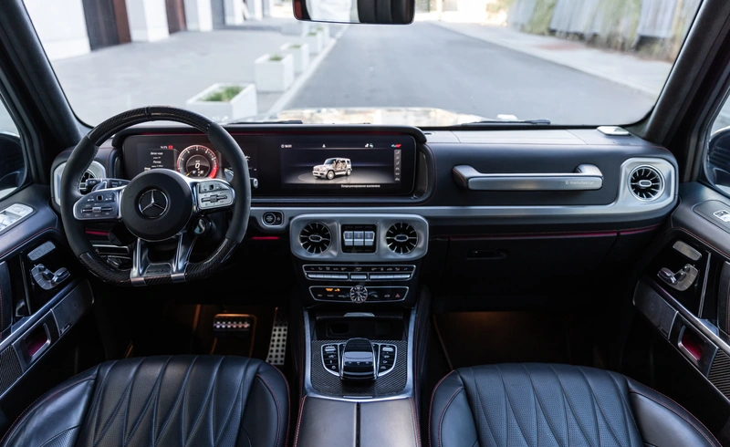 Интерьер Mercedes-AMG G63 с кожаной отделкой, спортивным рулём и цифровой панелью с дисплеем G-Class.