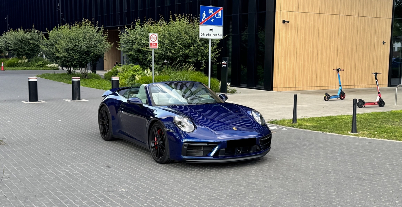 Porsche 911 Carrera 4 GTS Cabriolet w kolorze granatowym – widok z przodu z otwartym dachem, wynajem Warszawa SK CARS