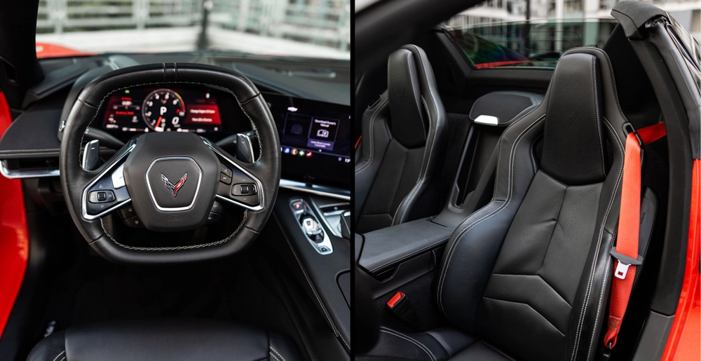 Kierownica Chevrolet Corvette C8 Stingray Cabrio z cyfrowymi zegarami oraz czarny fotel sportowy z czerwonym pasem bezpieczeństwa.