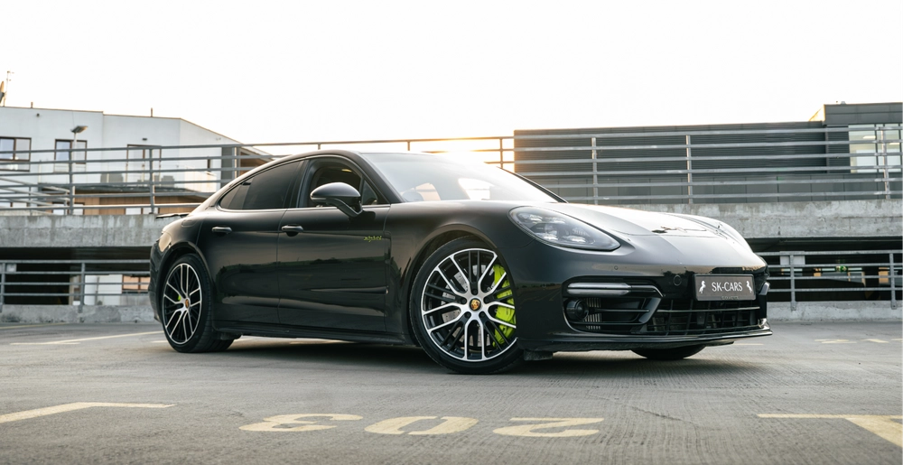 Черный Porsche Panamera Turbo S E-Hybrid на крыше паркинга в Варшаве, вид спереди слева, аренда премиального автомобиля SK CARS.