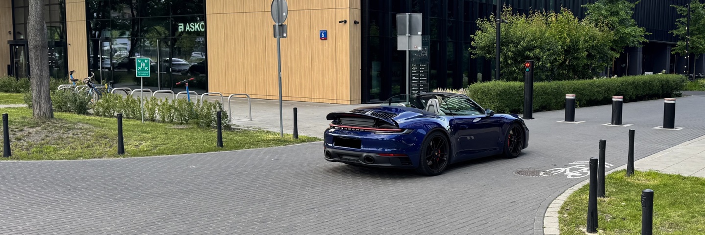 Porsche 911 Carrera 4 GTS Cabriolet w kolorze granatowym – widok od tyłu w ruchu, wynajem Warszawa SK CARS