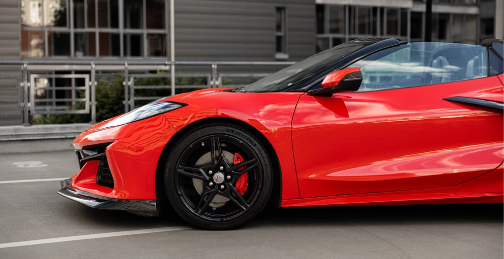 Czerwony Chevrolet Corvette C8 Stingray Cabrio z boku, czarna felga i czerwony zacisk hamulcowy.