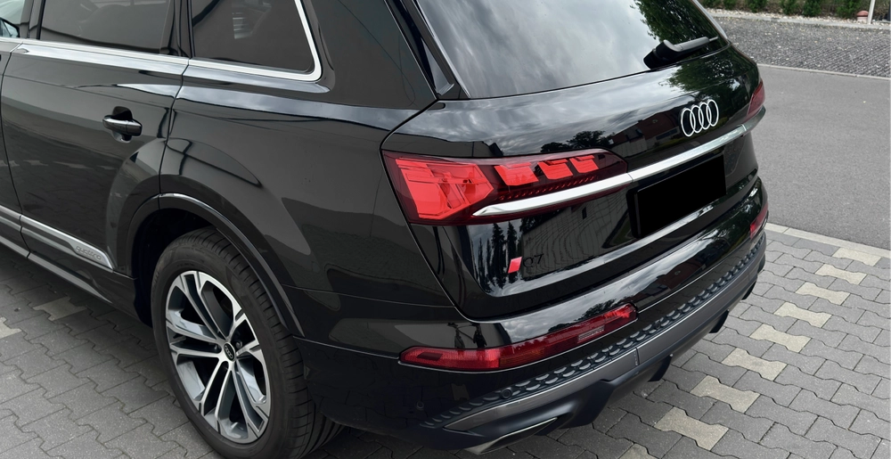 Audi Q7 50 TDI quattro S line – tył samochodu z logo S line i oznaczeniem modelu Q7, czarny lakier – wynajem Warszawa SK CARS