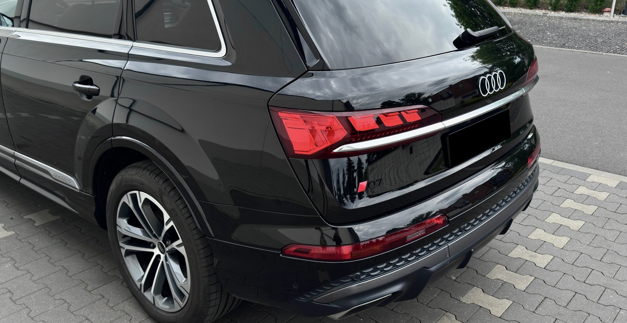 Audi Q7 50 TDI quattro S line – tył samochodu z logo S line i oznaczeniem modelu Q7, czarny lakier – wynajem Warszawa SK CARS