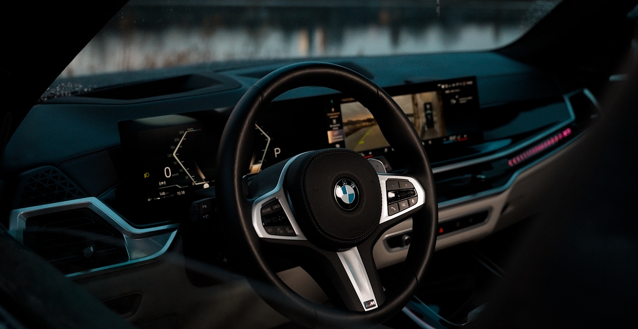 Sportowa kierownica BMW X7 xDrive 40 z logo M i cyfrowy kokpit z ekranem cofania. Luksus w każdym detalu. Dostępny w SK CARS Warszawa.