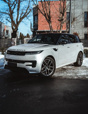 Biały Range Rover Sport zaparkowany w Warszawie, widok z przodu pod kątem, wynajem luksusowego SUV-a w SK CARS.