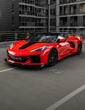 Czerwony Chevrolet Corvette C8 Stingray Cabrio z otwartym dachem, widok z przodu pod kątem, wynajem samochodu sportowego SK CARS w Warszawie.