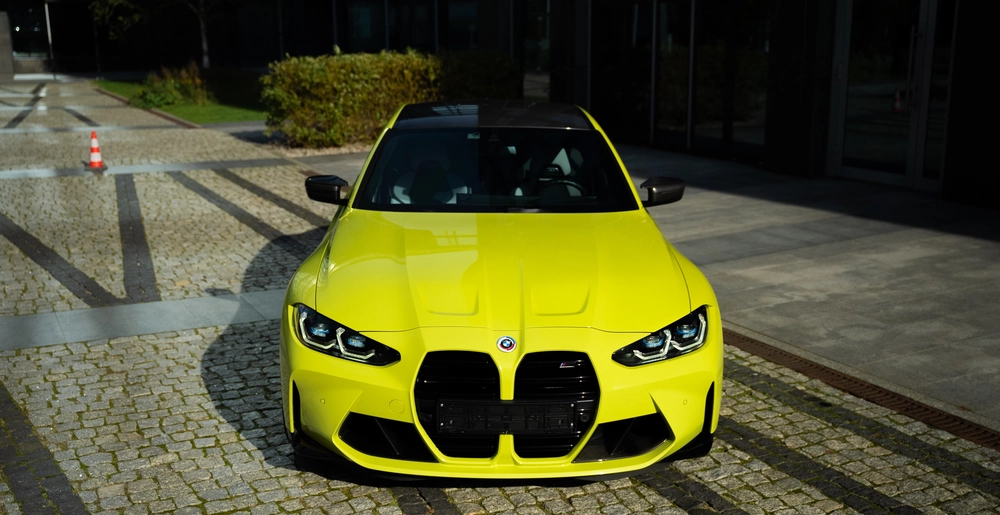 Wyświetlacz BMW M3 z żółtym sportowym autem i interfejsem ustawień pojazdu