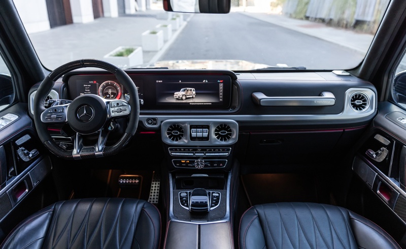 Interior of the Mercedes-AMG G63 with leather upholstery, sport steering wheel and digital G-Class display.